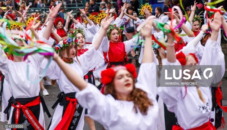 Pessoas vestem trajes tradicionais enquanto participam no Carnaval das Culturas em Berlim, Alemanha. O desfile envolve mais de 4 000 participantes que exibem as culturas dos seus países de origem. O Carnaval das Culturas é celebrado anualmente em Berlim desde 1996 e pretende ser um símbolo da diversidade e da coexistência pacífica. 