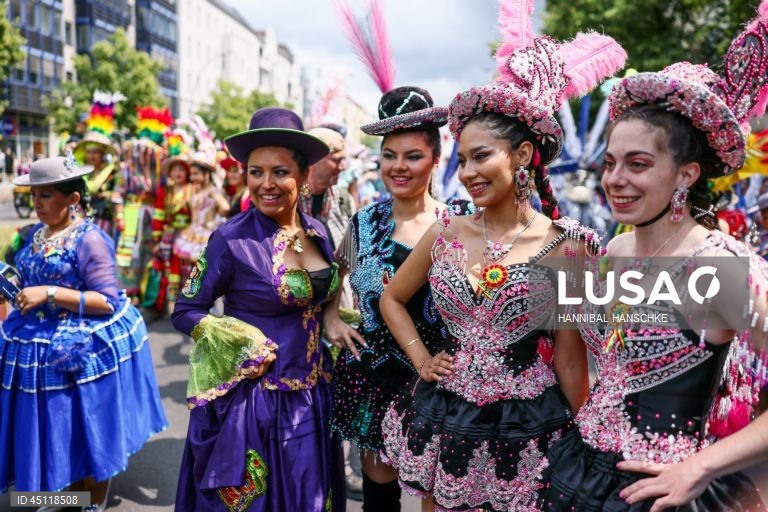 Pessoas vestem trajes tradicionais enquanto participam no Carnaval das Culturas em Berlim, Alemanha. O desfile envolve mais de 4 000 participantes que exibem as culturas dos seus países de origem. O Carnaval das Culturas é celebrado anualmente em Berlim desde 1996 e pretende ser um símbolo da diversidade e da coexistência pacífica. 