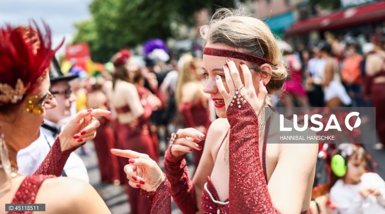 Pessoas vestem trajes tradicionais enquanto participam no Carnaval das Culturas em Berlim, Alemanha. O desfile envolve mais de 4 000 participantes que exibem as culturas dos seus países de origem. O Carnaval das Culturas é celebrado anualmente em Berlim desde 1996 e pretende ser um símbolo da diversidade e da coexistência pacífica. 