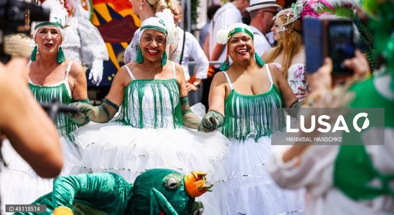 Pessoas vestem trajes tradicionais enquanto participam no Carnaval das Culturas em Berlim, Alemanha. O desfile envolve mais de 4 000 participantes que exibem as culturas dos seus países de origem. O Carnaval das Culturas é celebrado anualmente em Berlim desde 1996 e pretende ser um símbolo da diversidade e da coexistência pacífica. 