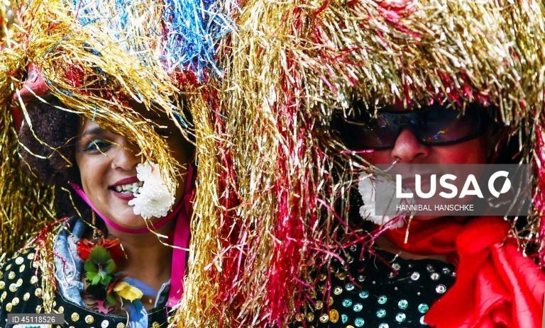 Pessoas vestem trajes tradicionais enquanto participam no Carnaval das Culturas em Berlim, Alemanha. O desfile envolve mais de 4 000 participantes que exibem as culturas dos seus países de origem. O Carnaval das Culturas é celebrado anualmente em Berlim desde 1996 e pretende ser um símbolo da diversidade e da coexistência pacífica. 