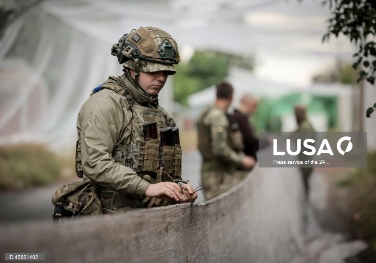 Ucrânia: Soldados da 24.ª brigada mecanizada com o nome do rei Danylo, instalam redes ao longo das estradas, para protegê-las de ataques com drones, numa cidade da linha da frente na região de Donetsk