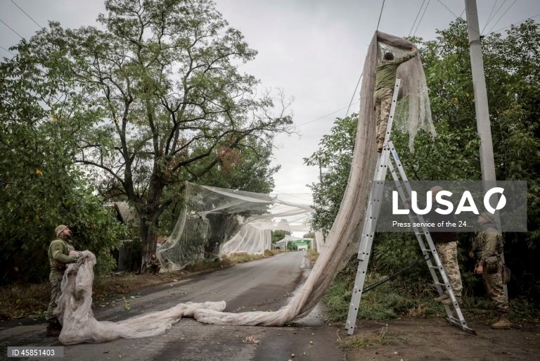 Ucrânia: Soldados da 24.ª brigada mecanizada com o nome do rei Danylo, instalam redes ao longo das estradas, para protegê-las de ataques com drones, numa cidade da linha da frente na região de Donetsk