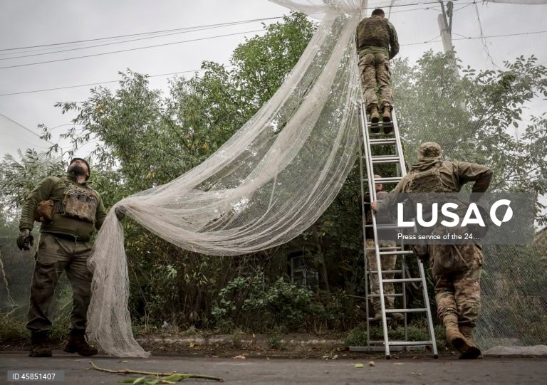 Ucrânia: Soldados da 24.ª brigada mecanizada com o nome do rei Danylo, instalam redes ao longo das estradas, para protegê-las de ataques com drones, numa cidade da linha da frente na região de Donetsk