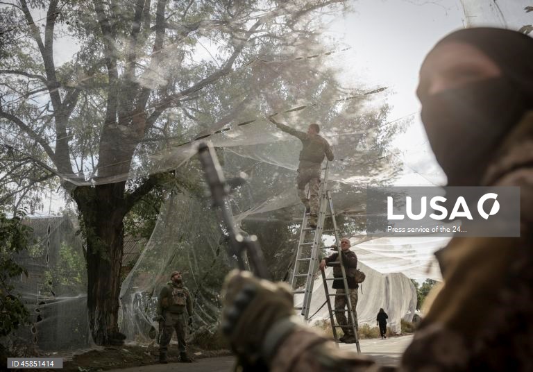 Ucrânia: Soldados da 24.ª brigada mecanizada com o nome do rei Danylo, instalam redes ao longo das estradas, para protegê-las de ataques com drones, numa cidade da linha da frente na região de Donetsk