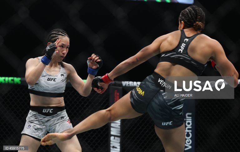 Jaqueline Amorim (vermelho) do Brasil e Mizuki Inoue (azul) do Japão em ação durante o UFC 321 na categoria peso palha feminino, em Abu Dhabi, Emirados Árabes Unidos.