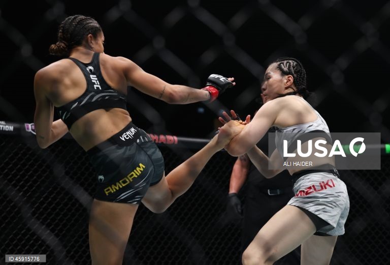 Jaqueline Amorim (vermelho) do Brasil e Mizuki Inoue (azul) do Japão em ação durante o UFC 321 na categoria peso palha feminino, em Abu Dhabi, Emirados Árabes Unidos.