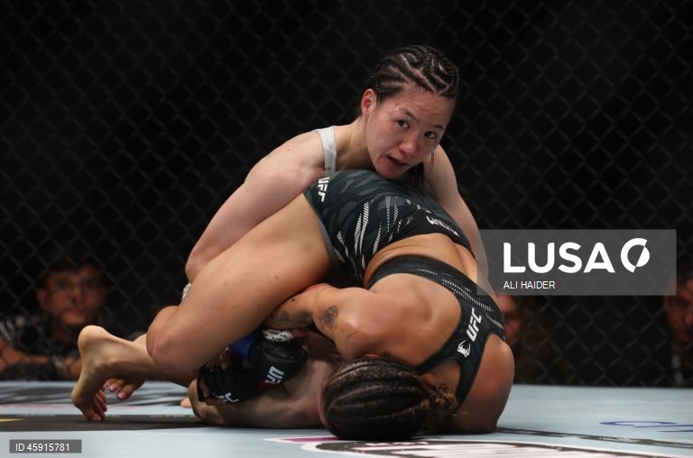 Jaqueline Amorim (vermelho) do Brasil e Mizuki Inoue (azul) do Japão em ação durante o UFC 321 na categoria peso palha feminino, em Abu Dhabi, Emirados Árabes Unidos.