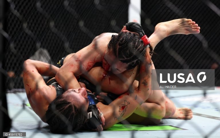 Jaqueline Amorim (vermelho) do Brasil e Mizuki Inoue (azul) do Japão em ação durante o UFC 321 na categoria peso palha feminino, em Abu Dhabi, Emirados Árabes Unidos.