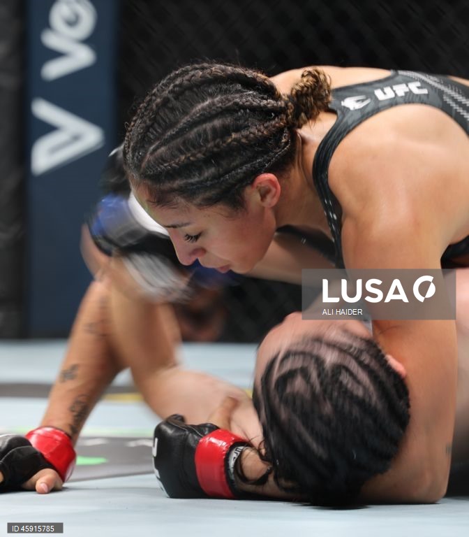 Jaqueline Amorim (vermelho) do Brasil e Mizuki Inoue (azul) do Japão em ação durante o UFC 321 na categoria peso palha feminino, em Abu Dhabi, Emirados Árabes Unidos.