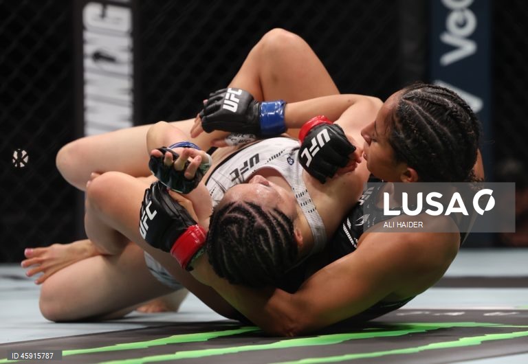 Jaqueline Amorim (vermelho) do Brasil e Mizuki Inoue (azul) do Japão em ação durante o UFC 321 na categoria peso palha feminino, em Abu Dhabi, Emirados Árabes Unidos.