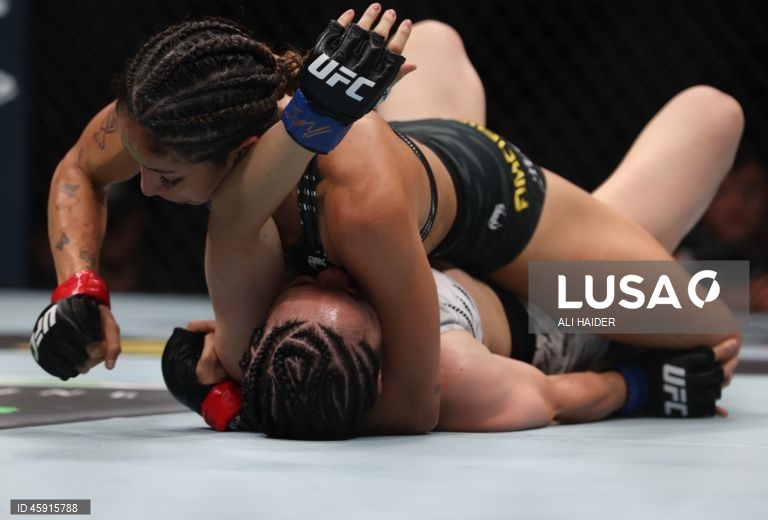 Jaqueline Amorim (vermelho) do Brasil e Mizuki Inoue (azul) do Japão em ação durante o UFC 321 na categoria peso palha feminino, em Abu Dhabi, Emirados Árabes Unidos.