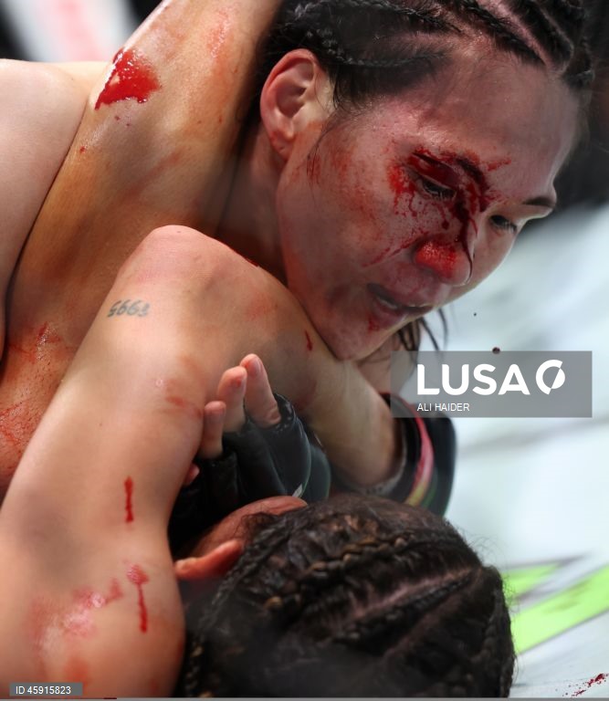 Jaqueline Amorim (vermelho) do Brasil e Mizuki Inoue (azul) do Japão em ação durante o UFC 321 na categoria peso palha feminino, em Abu Dhabi, Emirados Árabes Unidos.