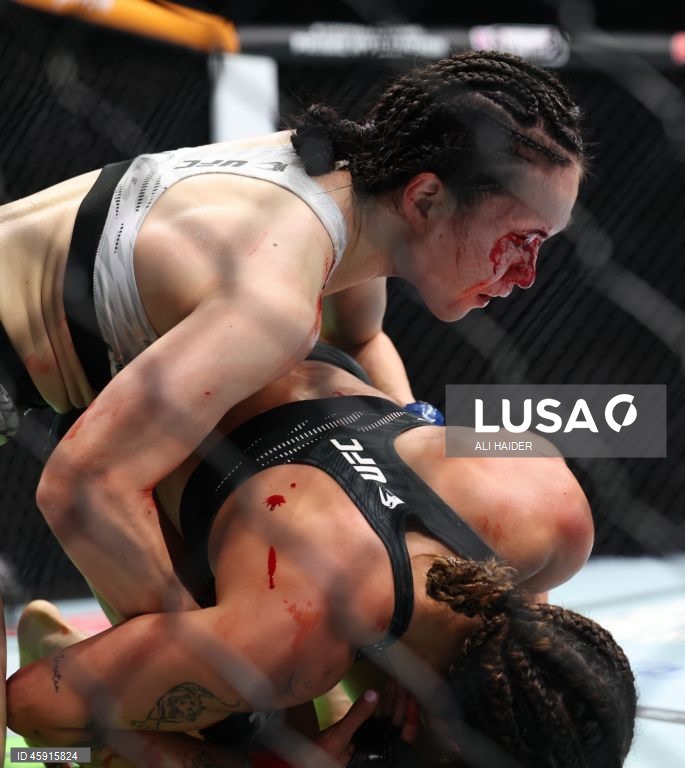 Jaqueline Amorim (vermelho) do Brasil e Mizuki Inoue (azul) do Japão em ação durante o UFC 321 na categoria peso palha feminino, em Abu Dhabi, Emirados Árabes Unidos.