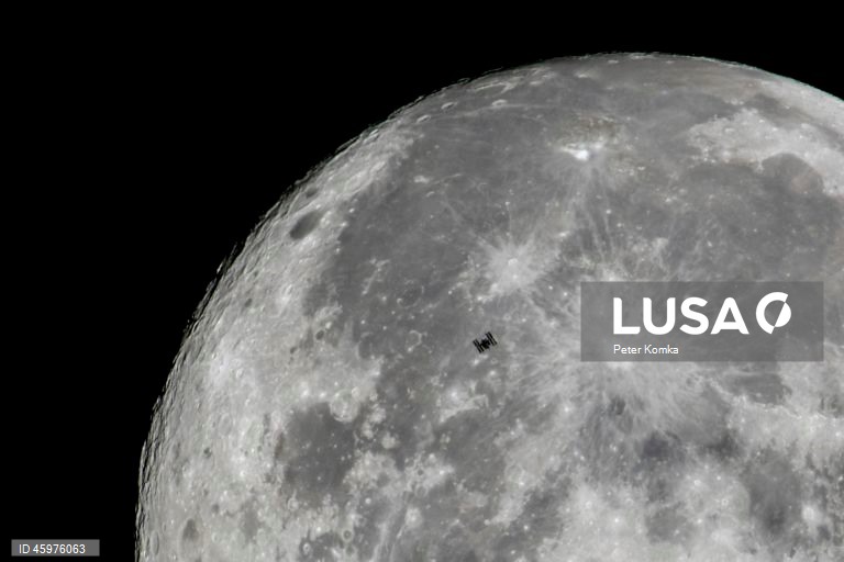 A Estação Espacial Internacional (ISS) em órbita da Terra é capturada em primeiro plano da Lua a partir de Szurdokpuspoki, norte da Hungria.