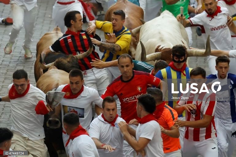 Os corredores, conhecidos como «mozos», são perseguidos pelos touros da fazenda La Palmosilla durante a sexta corrida de touros do festival de San Fermín, em Pamplona, no norte de Espanha.